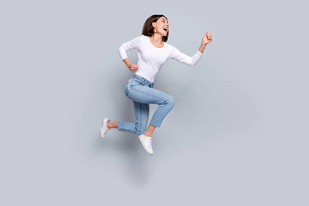 istock Photo of charming pretty lady dressed white clothes smiling running fast looking empty space jumping high isolated grey color background 2219769547