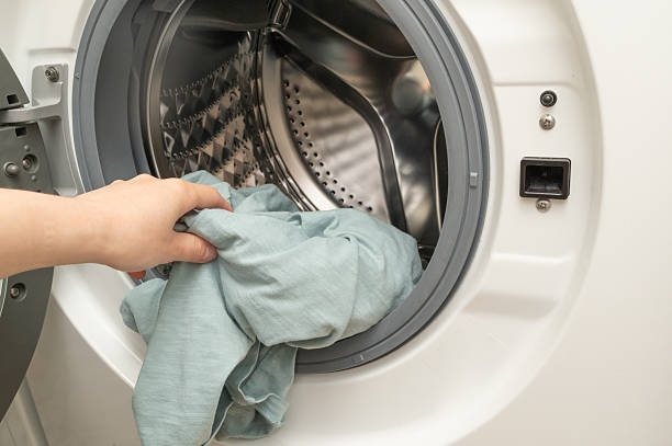 istock A person is currently busy putting clothes into a washing machine 2219769656