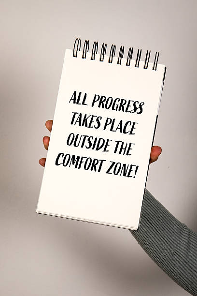 istock Motivational Quote About Growth and Progress Outside Comfort Zone on Notepad Held by Hand 2219770835