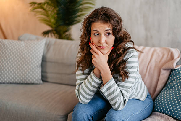 istock Sad Young Woman Sitting At Home On The Sofa 2219773805