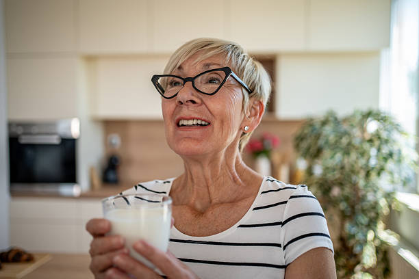 istock Happy senior woman drinking milk in a modern kitchen 2219774297