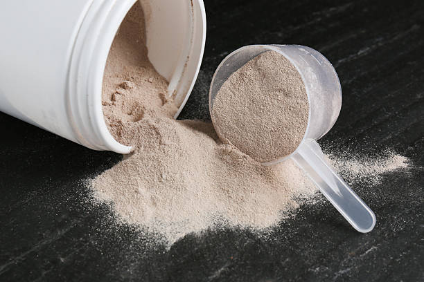 istock Jar and scoop with protein powder on dark textured table 2219776253
