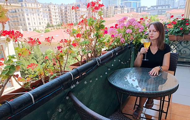 istock woman with coctail is sitting on the blossom balcony 2219776533