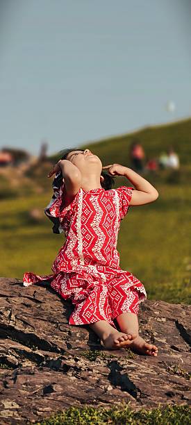 A serene day: baby sitting in grass with mountain views