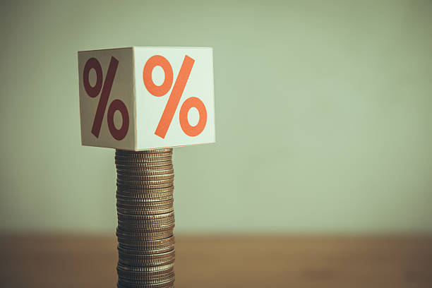 istock Heavy interest rate (percentage sign) presses on slow growth stack coins on wooden table. 2219778489
