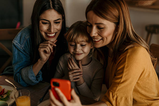 istock Smiling family looking at a smartphone at home 2219785529