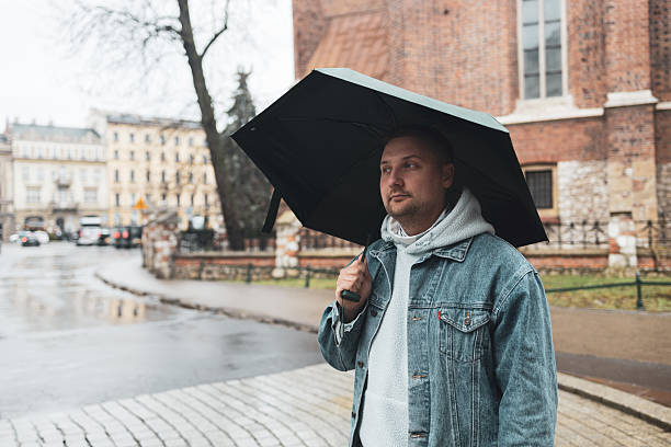 istock Man Walking with Umbrella on a Rainy Day 2219788751