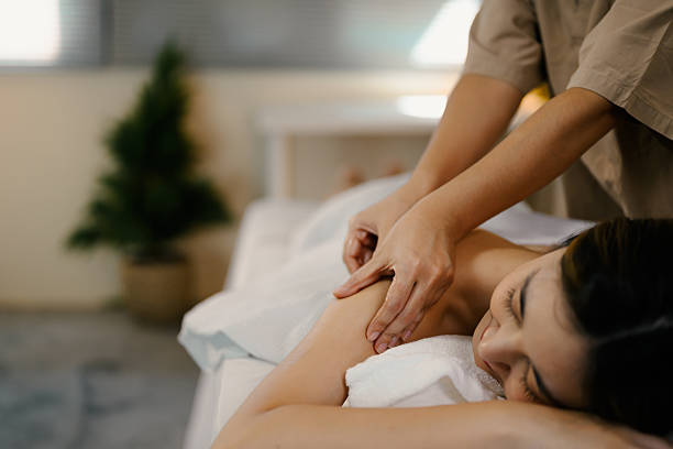 istock Closeup relaxed woman lying on massage table while massage therapist massages her 2219789314
