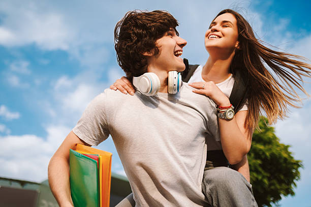 Happy students piggybacking outdoors having fun