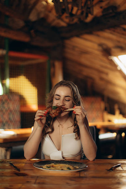 istock Woman Enjoying a Delicious Meal in a Cozy Rustic Restaurant Setting 2219795659