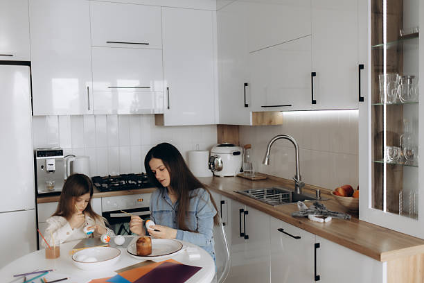 istock Mother and Daughter Decorating Eggs in a Modern Kitchen Together 2219798706