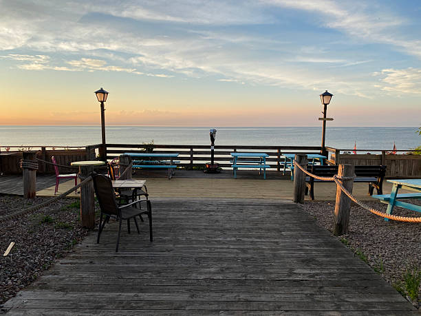 istock Scenic Lakeside Deck at Sunset with Seating and Viewing Scope 2219799673