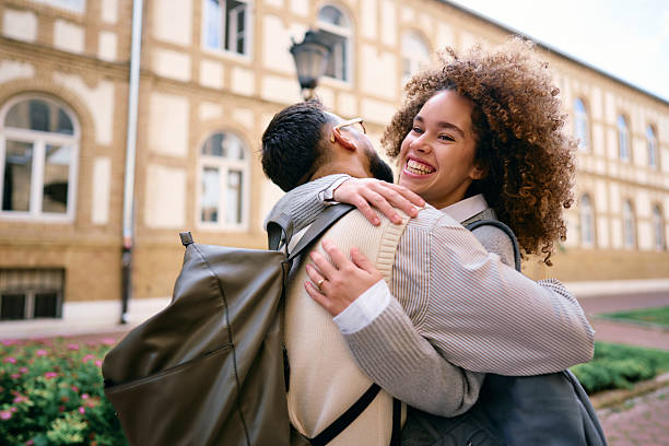istock Two happy students hugging each other in front of their university 2219800824