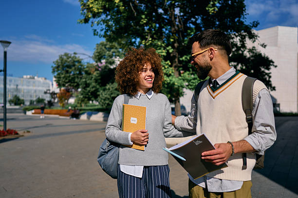 istock Two happy students walking and talking on university campus 2219801195
