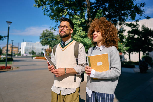 istock Two cheerful students walking and talking on university campus 2219801219