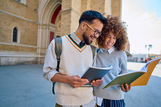 istock Two happy students studying together outside university building 2219801271