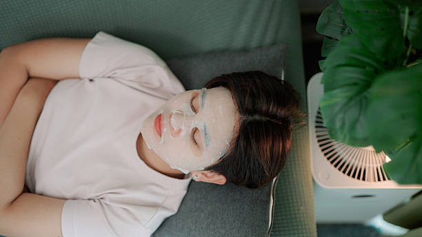 istock Asian woman sleeping on sofa while using facial mask 2219802299