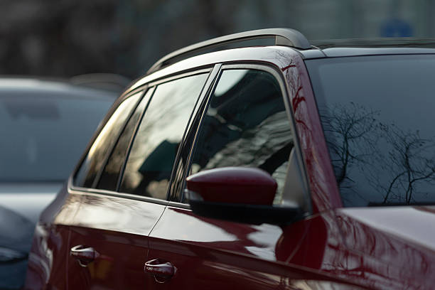 istock Red Car Detail Featuring a Beautiful Reflection on a City Window 2219804303