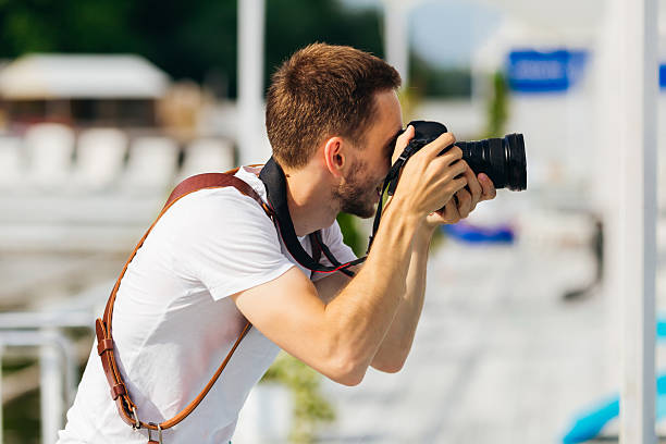 istock beard man in white T-shirt makes pictures on digital camera. pro 2219811073