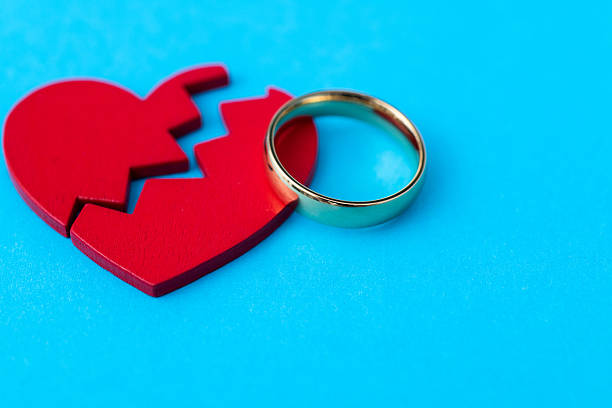istock Wedding ring with broken heart on blue background 2219813877