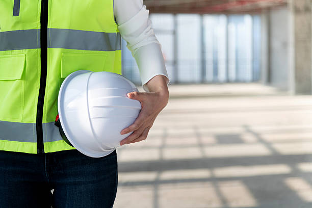 istock Close up of female construction worker holding white hardhat 2219814288
