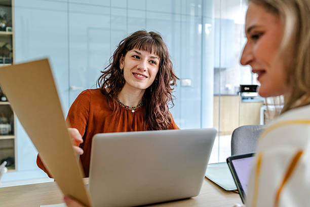 istock Businesswomen collaborating in a modern office setting, engaged in productive discussions about project details 2219814824