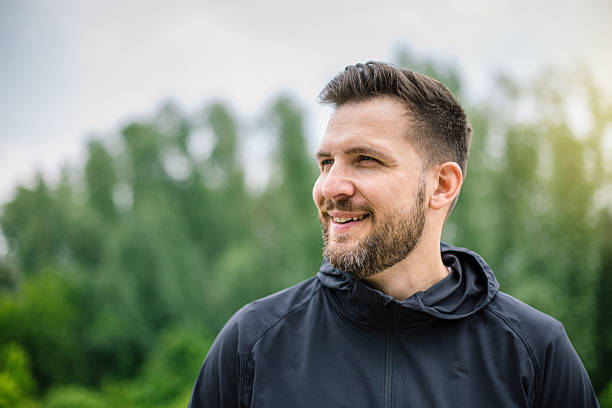 istock Young man smiling and looking away in a park 2219814859