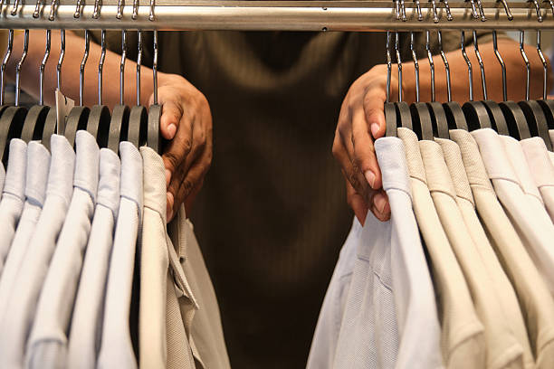 istock Customer browsing shirts on clothing rack in retail store 2219814969