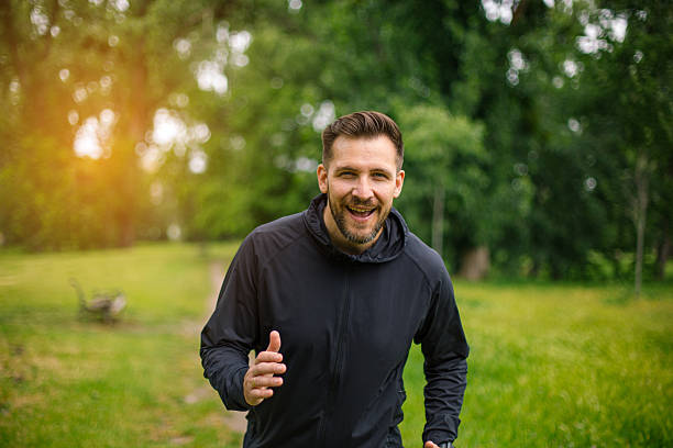 istock Happy man running in a green park during summer 2219817865