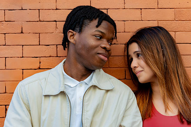 istock Young couple gazing at each other with affection by brick wall 2219819102