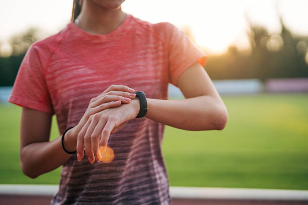 istock Young sportswoman checking fitness tracker during training at sunset 2219819217