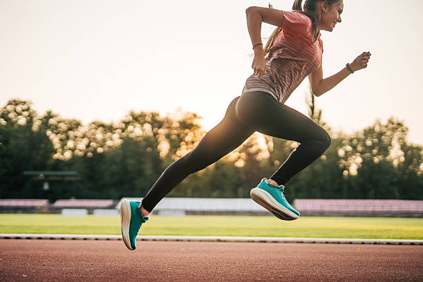 istock Young female athlete running on track at sunset 2219819268