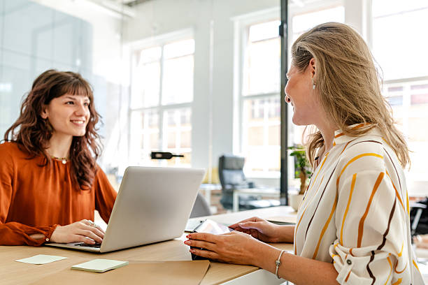 istock Businesswomen engaged in productive discussion in a modern office setting during daytime 2219820433