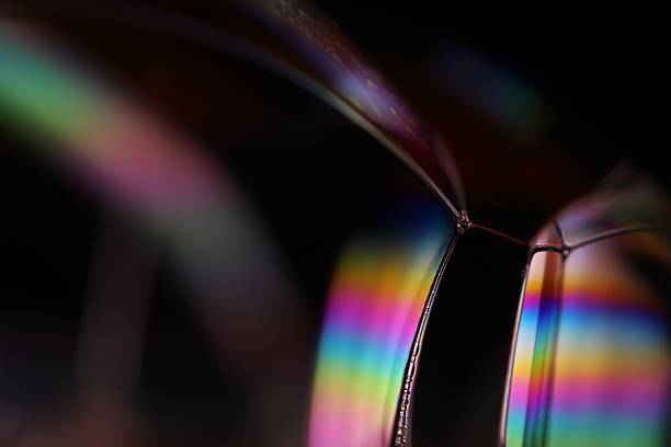 istock Bright rainbow reflection of liquid on black background 2219820750
