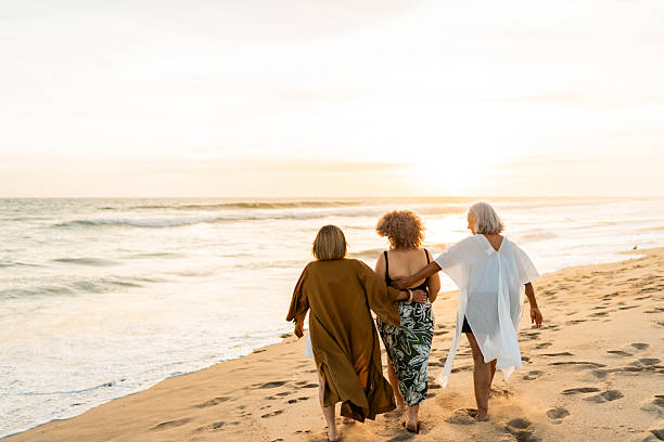 istock Senior friends women walking on the beach 2219821976