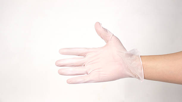 istock Hands is wearing  a disposable white latex or nitrile glove on white backround. 2219825258