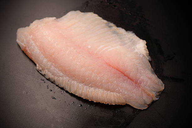 istock Fresh tilapia fillet on black background, top view. 2219826639