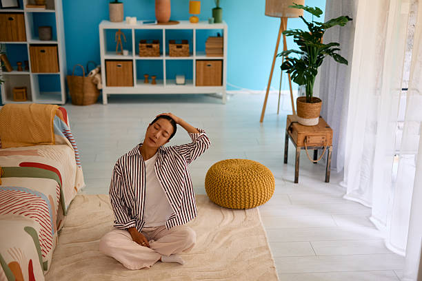 istock Young Woman Stretching Neck at Home on Carpet 2219827110