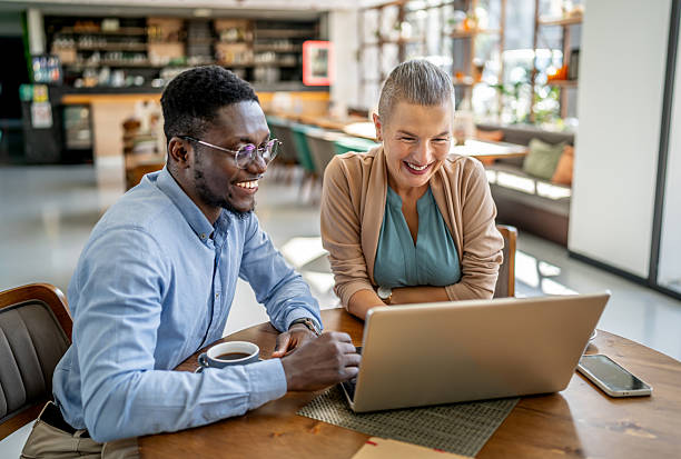 istock Business people working on laptop in cafe, enjoying collaboration 2219828098