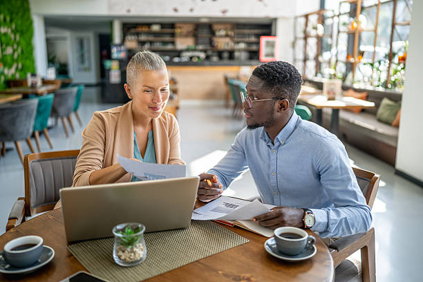 istock Business people working on charts and graphs in a cafe 2219828387