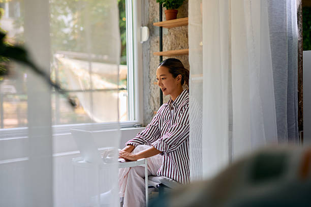 istock Young Asian Freelancer Working From Home on Laptop Near Window 2219828697