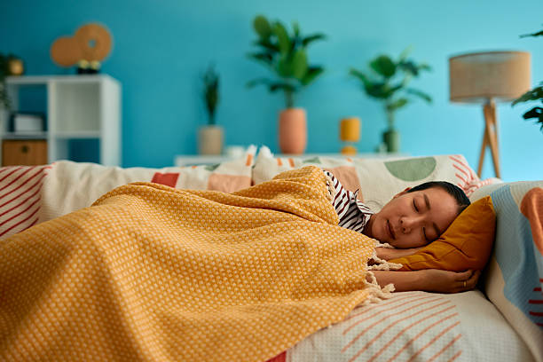 istock Young woman sleeping peacefully on a comfortable sofa in her modern living room 2219828878