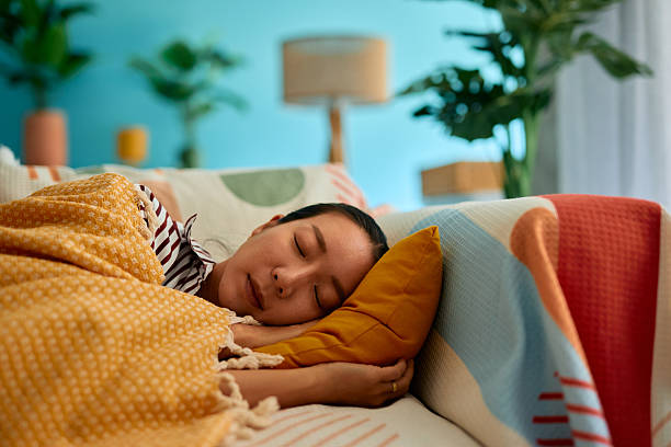 istock Serene young woman sleeping peacefully on a comfortable sofa in her cozy living room 2219829114