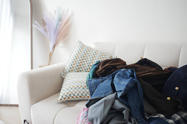 istock Piles of clothes on a couch in a cozy living room space 2219829498