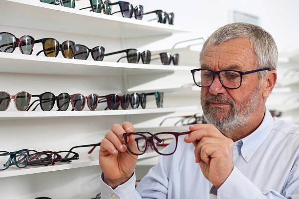 istock Senior Man Choosing Eyeglasses in Optical Store 2219829536