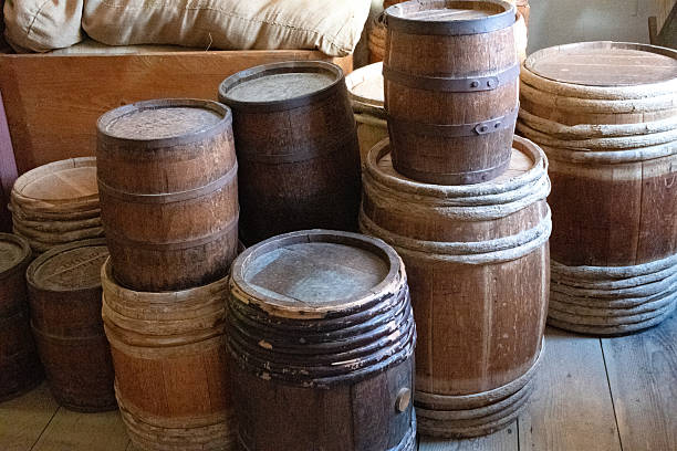 istock Stacked wood barrels in old storage room 2219833860