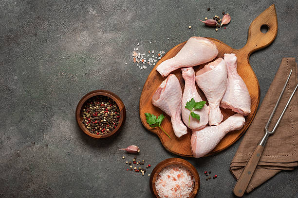 istock Raw chicken legs and spices on dark rustic background, top view, flat lay 2219836828