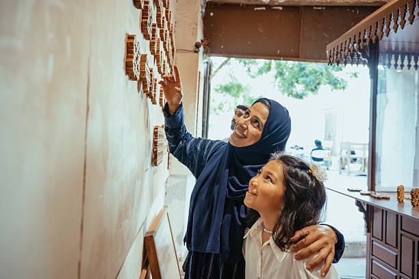 Candid moment in a craftsman's workshop with a Arab mother with daughter learning about traditional woodworking techniques