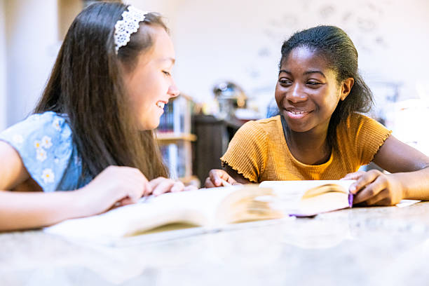 istock Two middle school aged girls reading in the library 2219845652