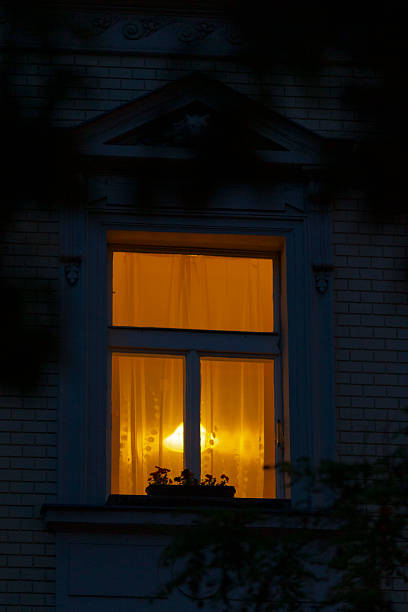 istock A beautifully illuminated window shines bright in a darkened house at night 2219847955